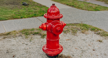 Red fire hydrant on grass beside sidewalk