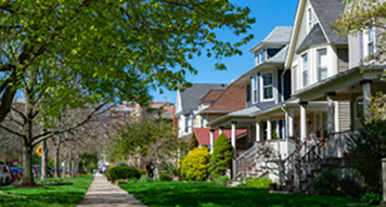 Tree-lined residential street with houses