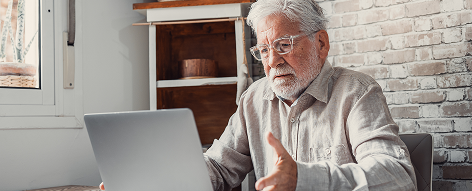 Older man reviewing laptop to avoid utility scams